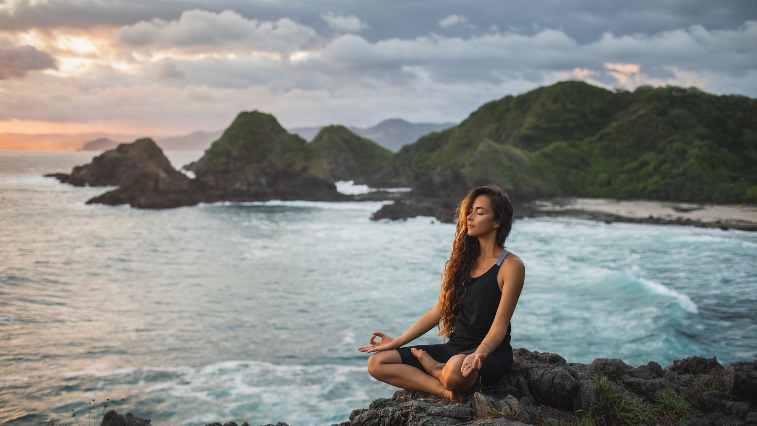 Девушка медитирует на берегу моря