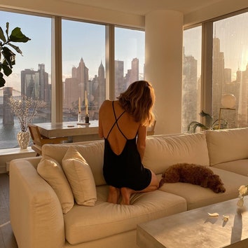 Девушка на диване смотрит в панорамное окно