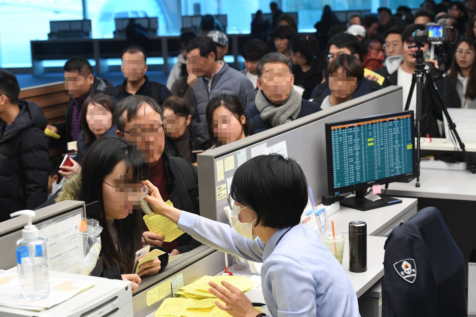 Проверка температуры прилетевших из Китая пассажиров сотрудниками аэропорта в Южной Корее.