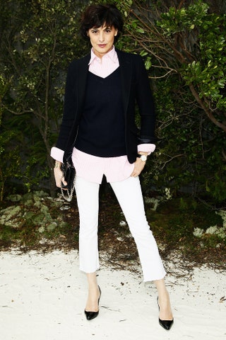 Инес де ла Фрессанж в розовой клетчатой рубашке черном джемпере и белых брюках