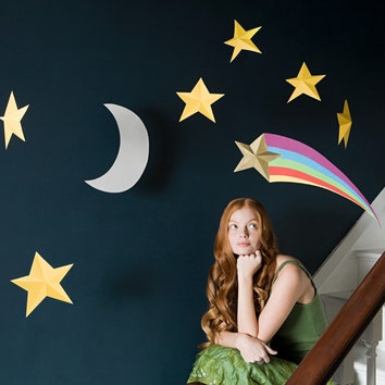 Девушка на фоне стены украшенной звездами и луной