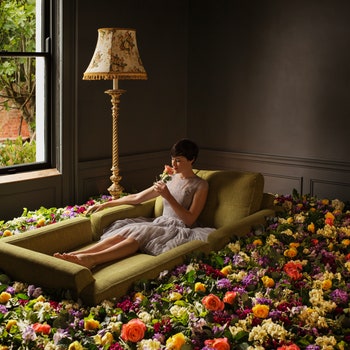 Женщина сидящая на диване в цветах