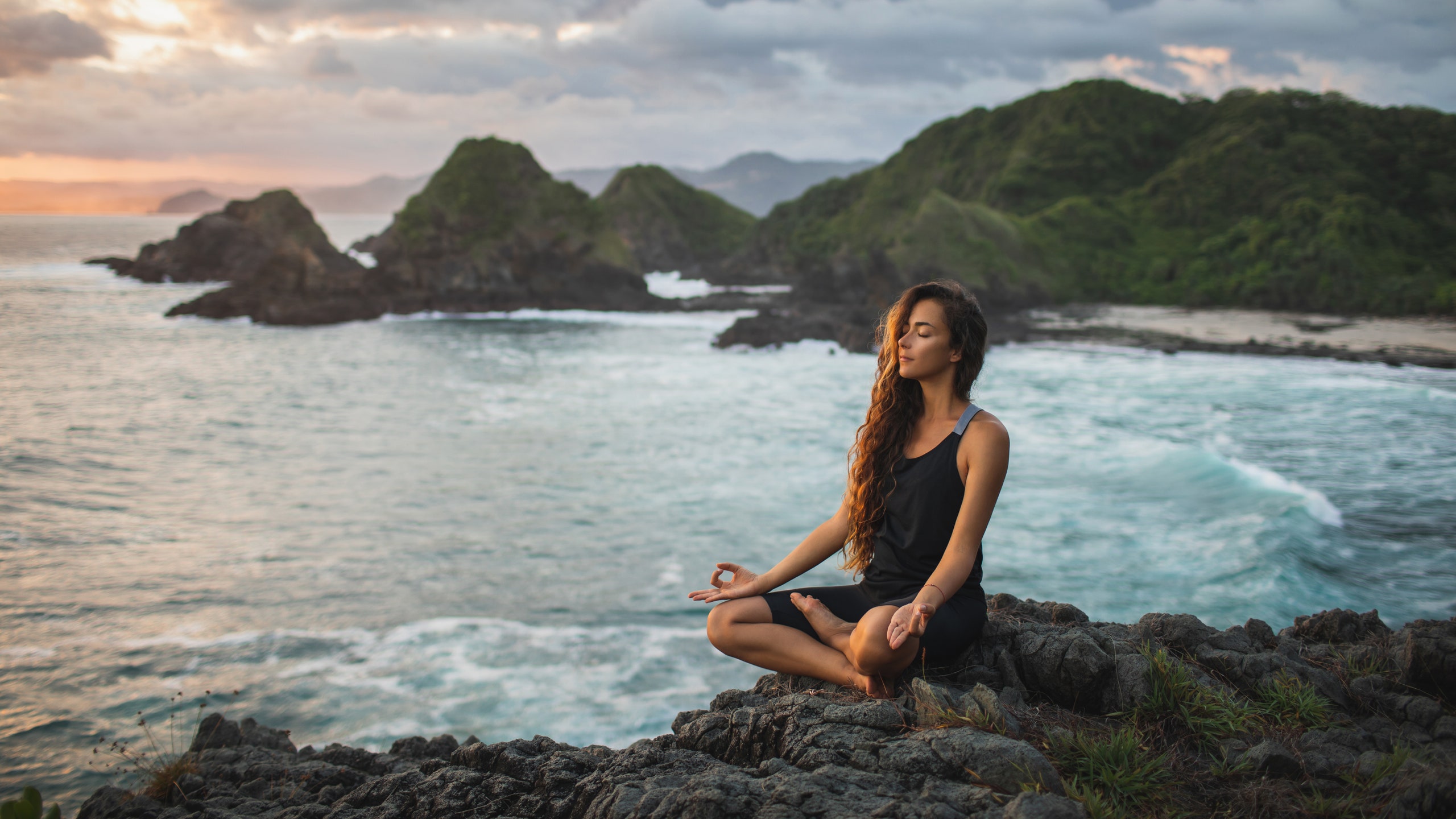 Девушка медитирует на побережье