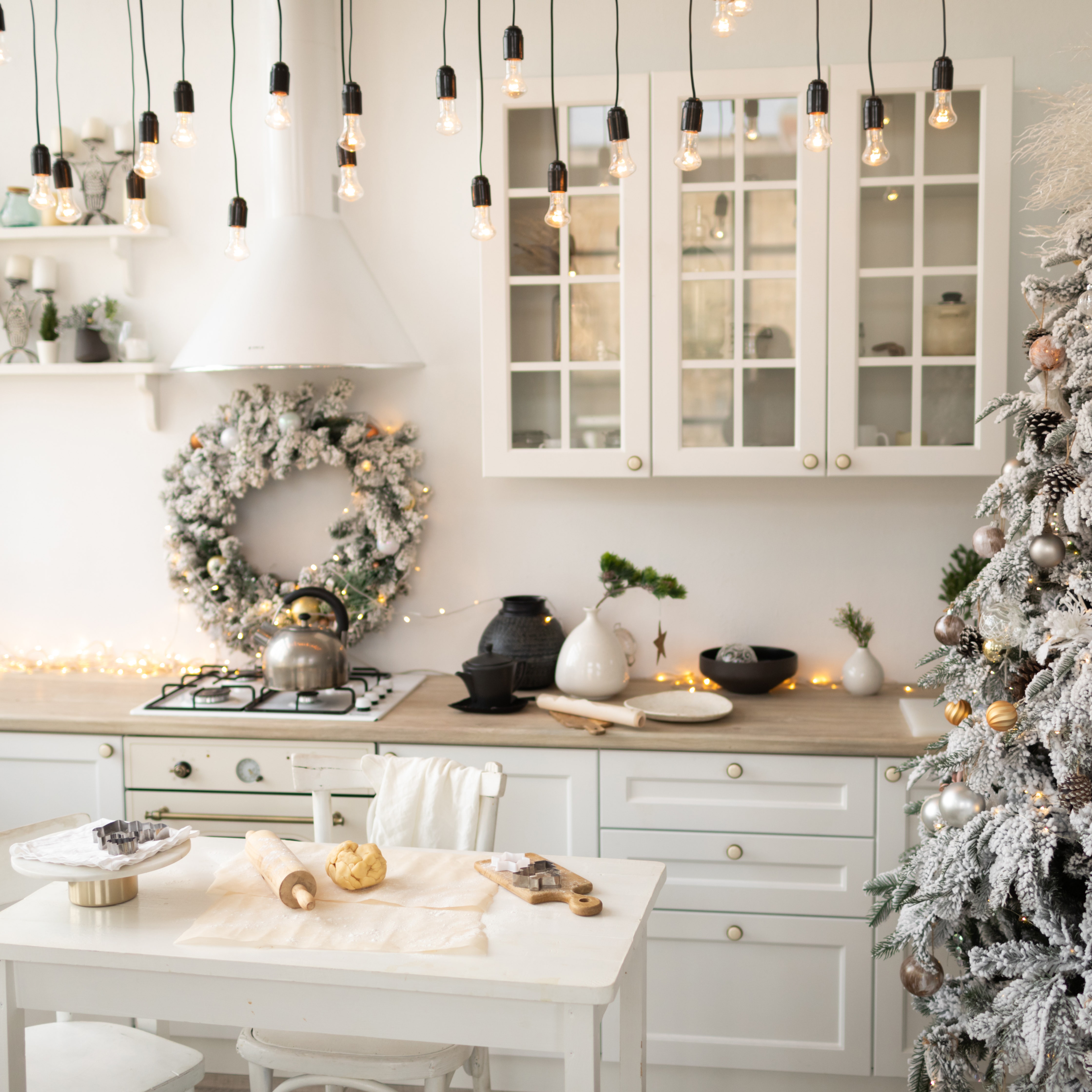 Interior white kitchen and light christmas decor. Preparing homemade cookies at kitchen. Festive kitchen in Christmas...