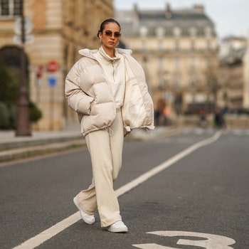 PARIS FRANCE  FEBRUARY 20 Camille Coyere wears sunglasses a white oversized winter puffer long coat a white pullover...