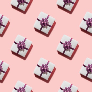 Seamless pattern of pink giftboxes with purple bow with shadow on pink. Beautiful holiday gift coupon or flyer.