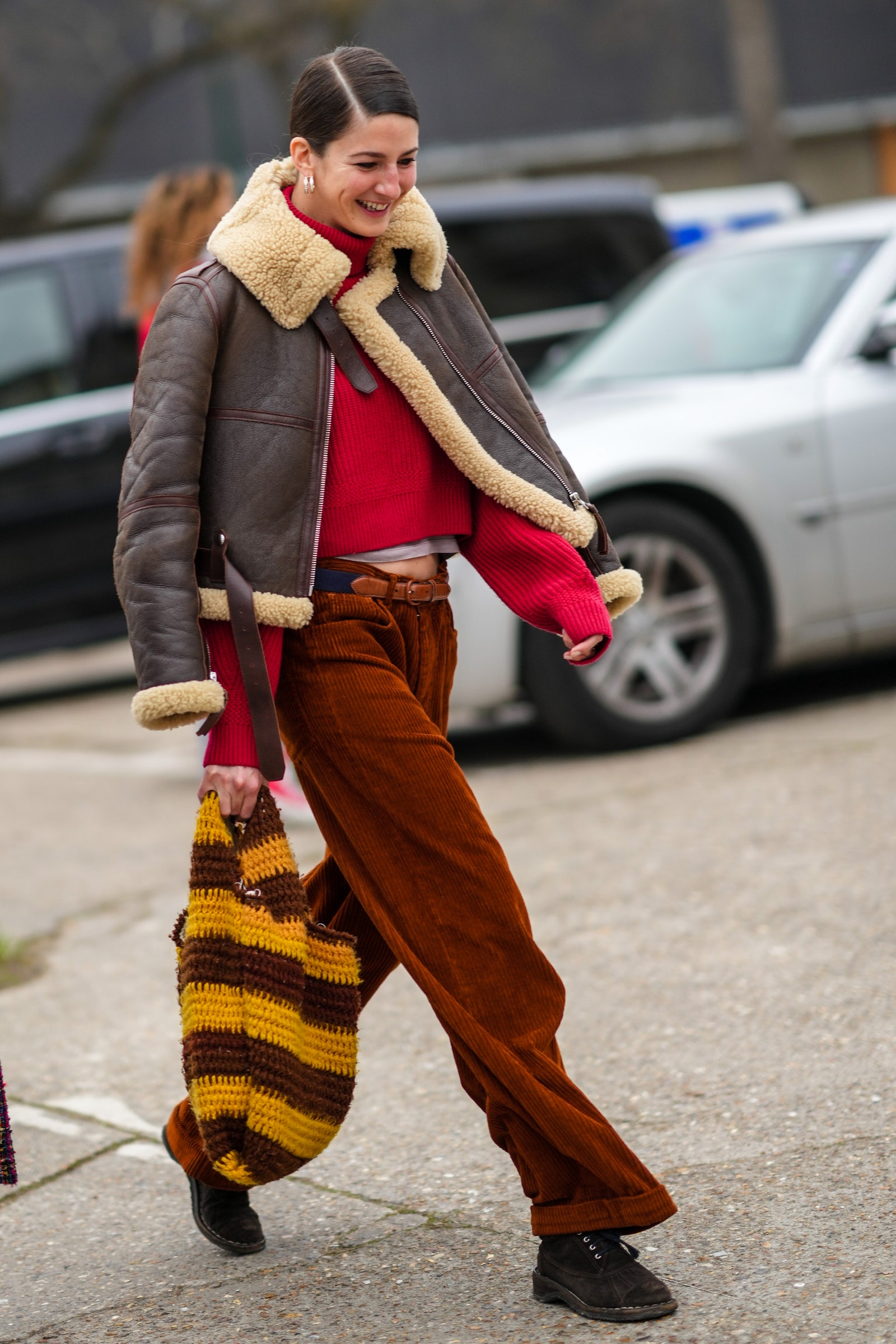 PARIS FRANCE  JANUARY 25 A model wears a red turtleneck pullover a white tshirt a brown leather with large sheep borders...