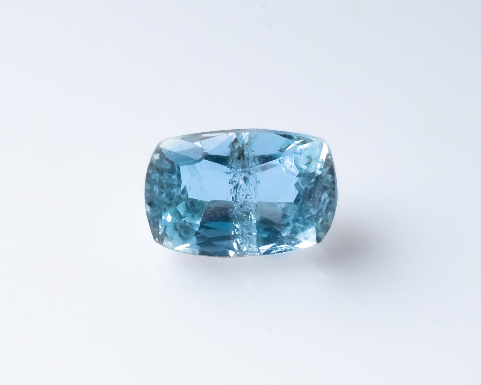 Natural faceted blue aquamarine on the white background